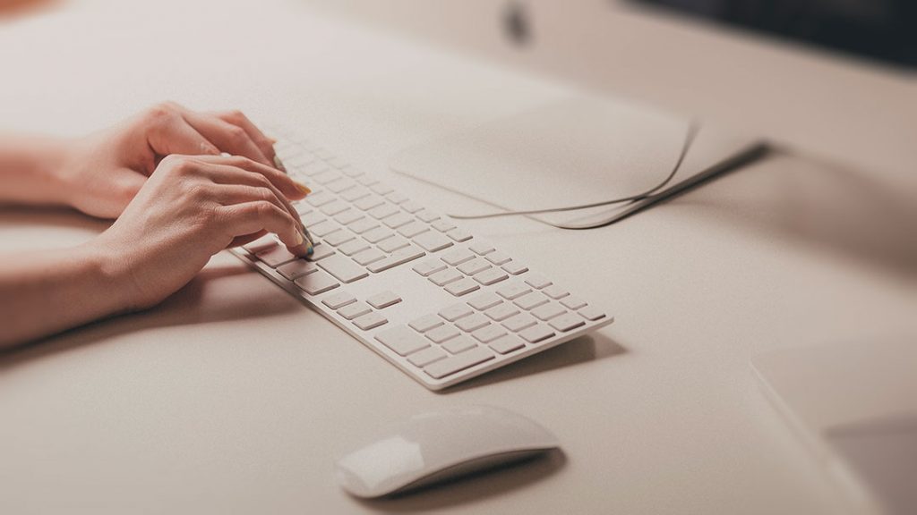 Une personne tape sur un clavier d'ordinateur